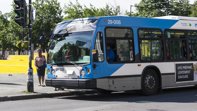 Des passagers montent à bord d'un autobus de la STM, à Montréal.