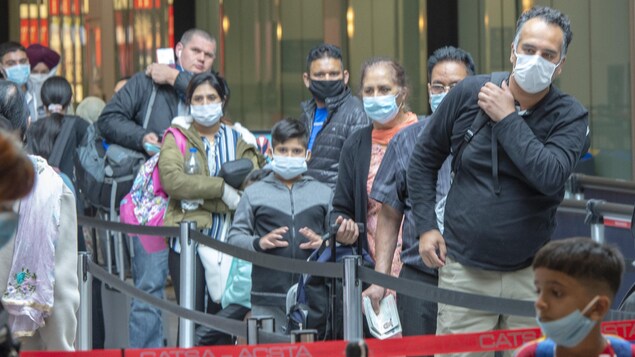 Des passagers attendent de passer un contrôle de sécurité.