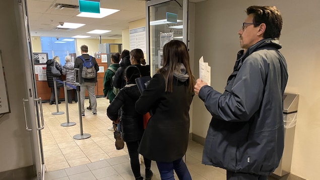 Des personnes en file au bureau des passeports du centre-ville de Toronto.