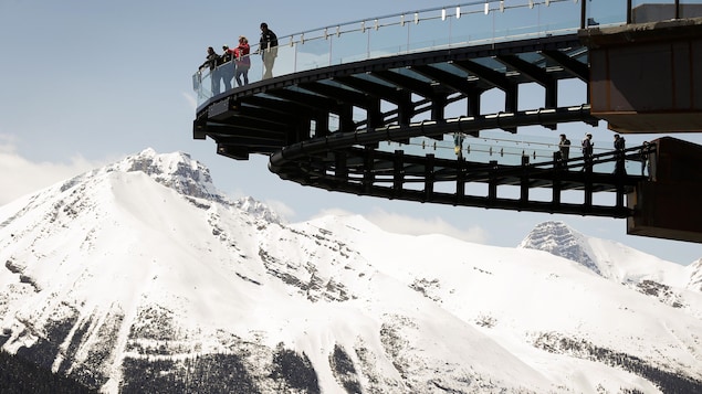 Des gens sur une passrelle suspendue.
