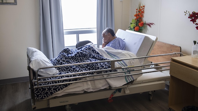 Un patient âgé dans un lit d'hôpital.
