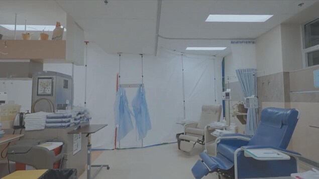 Un rideau de plastique est installé derrière des fauteuils destinés aus traitements de chimiothérapie. 