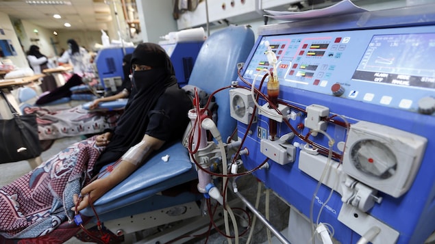 Une femme est branchée à l'équipement de dialyse.