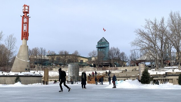 Des patineurs sur la rivière devant La Fourche.