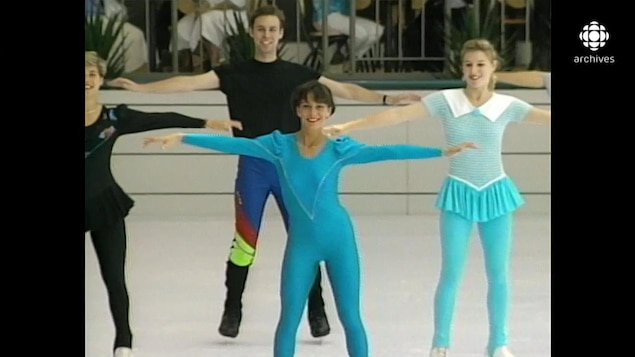 Quatre patineurs en prestation sur une patinoire intérieure, dont deux portant des léotards fluos