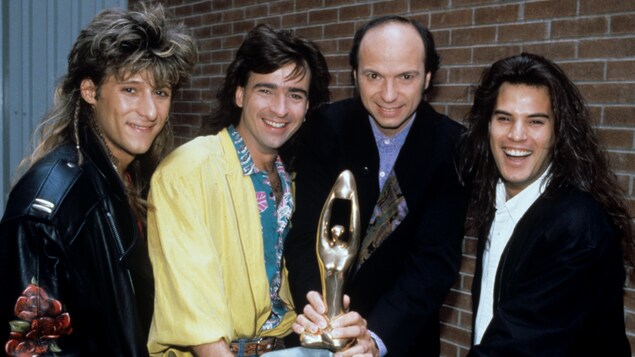 Les membres du groupe Les BB, François Jean, Alain Lapointe et Patrick Bourgeois, en compagnie de l'animateur du Gala de l'Adisq, Michel Rivard, tenant un trophée Félix dans ses mains. C'était en 1990. Les membres du groupe Les BB, François Jean, Alain Lapointe et Patrick Bourgeois, en compagnie de l'animateur du Gala de l'Adisq, Michel Rivard, tenant un trophée Félix dans ses mains. C'était en 1990.