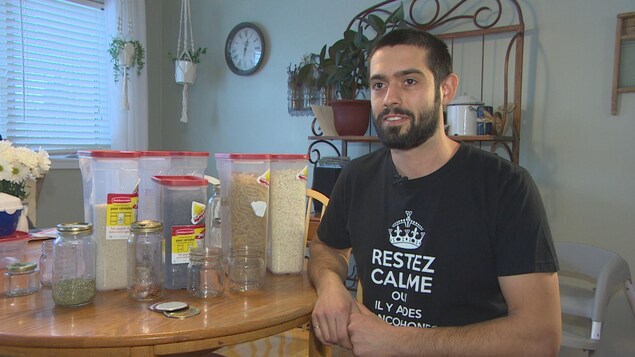 Patrick Lessard devant des bocaux remplis de produits achetés en vrac.