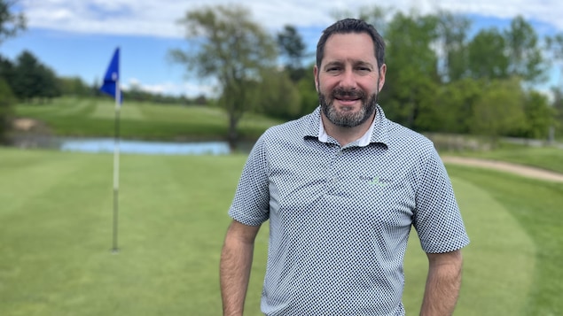 Un homme devant un terrain de golf.