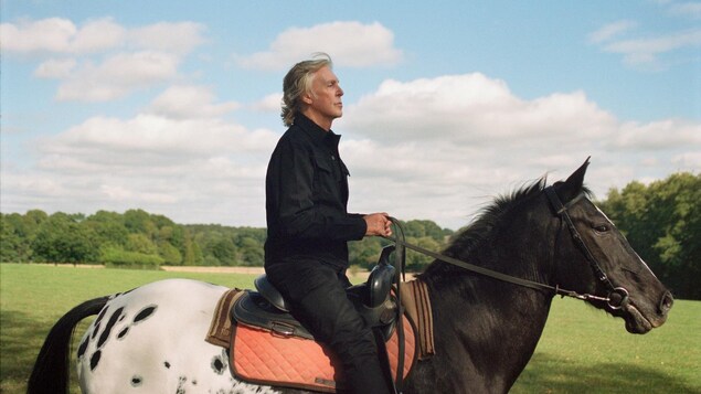 Un homme à cheval vu de profil. 