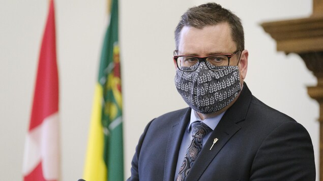 Paul Merriman, portant son masque, lors d'une conférence.