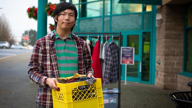 Paul Wu tient une boîte qui contient des vêtements.