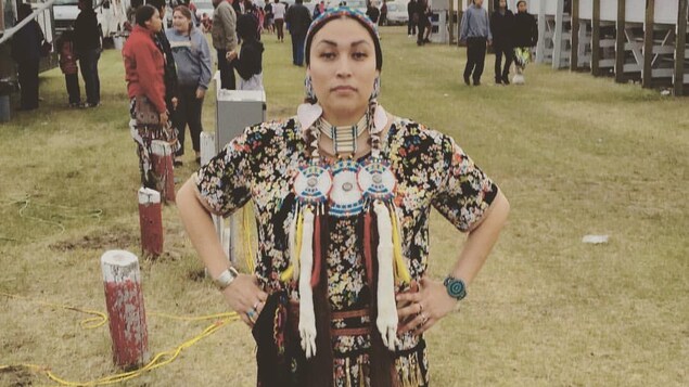Une femme autochtone porte des vêtements pour un pow-wow. Une femme autochtone porte des vêtements pour un pow-wow.
