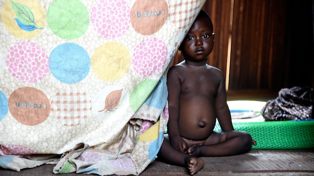 Un enfant assis sur le sol.