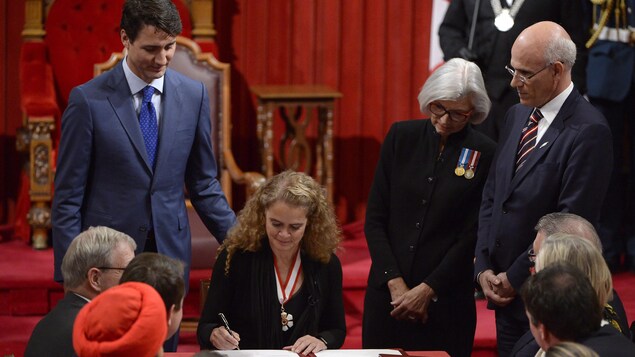 Julie Payette assise à une table au Sénat. Julie Payette assise à une table au Sénat.