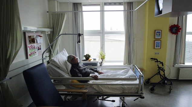 Un homme couché dans un lit d'hôpital.