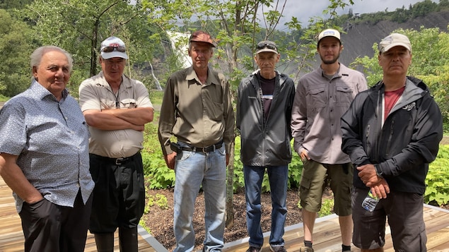 Six hommes posent devant la chute Montmorency.