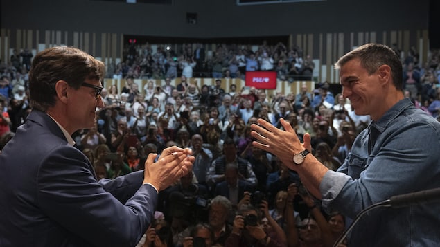 Le 9 mai 2024, Pedro Sanchez et Salvador Illa s'applaudissent sur scène devant une foule.