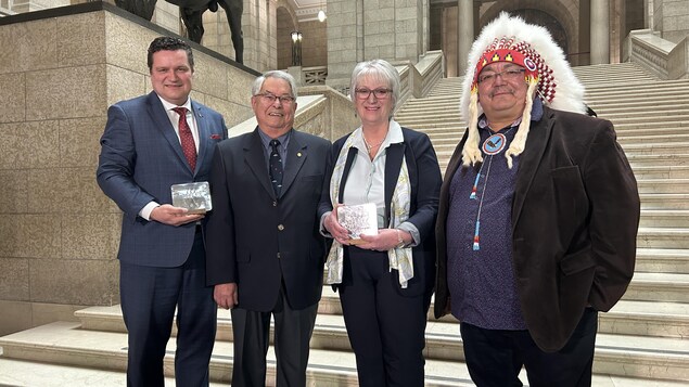 Quatre personnes, dont la ministre de la Réconciliation avec les peuples autochtones et des Relations avec le Nord, Eileen Clarke, posent à l'intérieur du Palais législatif du Manitoba, le 7 février 2023. 
