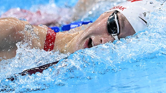 Gros plan sur le visage de Penny Oleksiak dans l'eau durant sa nage. 