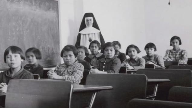 Des étudiants et une religieuse posent dans une salle de classe du pensionnat indien Cross Lake, à Cross Lake, au Manitoba, sur une photo d'archive.