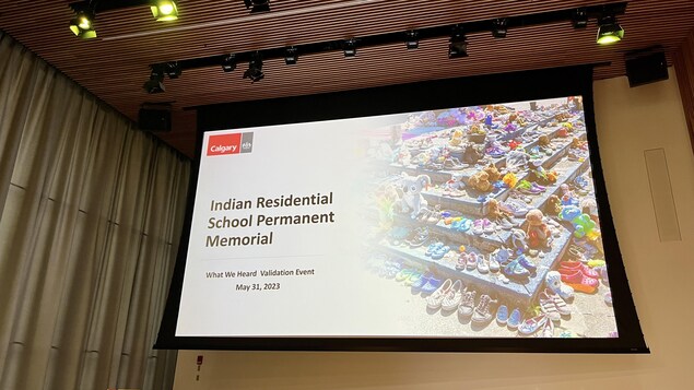 Une diapositive projetée sur un écran affiche Indian Residential School Permanent Memorial ( monument permanent des pensionnats autochtones).