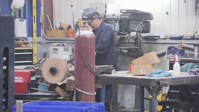 Un travailleur avec une visière dans une usine. Un travailleur avec une visière dans une usine.