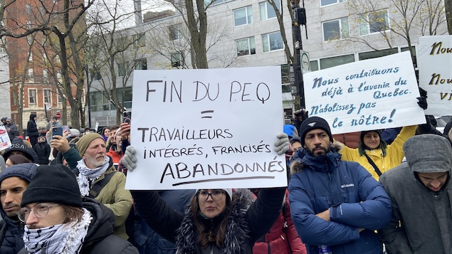 Des personnes tenant des pancartes dans la rue.