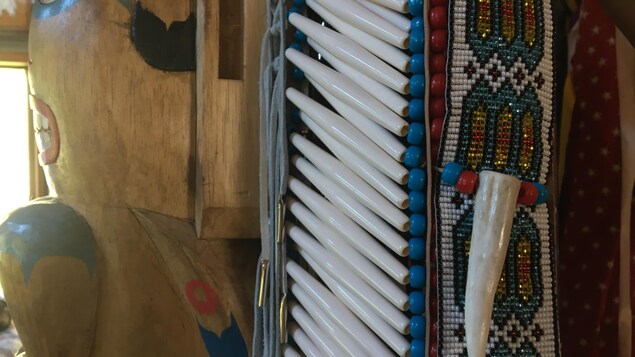 Gros plan sur des perles et une dent qui décorent un habit autochtone traditionnel. Gros plan sur des perles et une dent qui décorent un habit autochtone traditionnel.