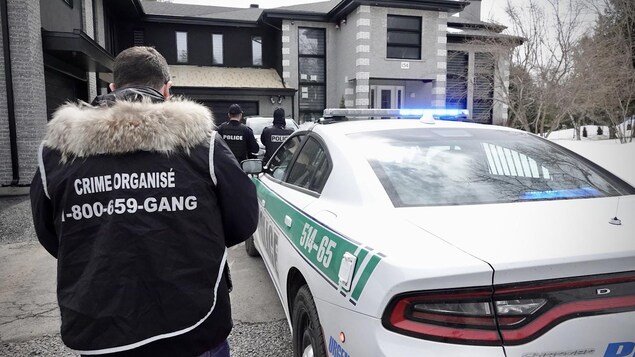 Des policiers devant une maison. 