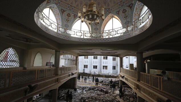 Le luxueux dôme de la mosquée surplombe des débris.