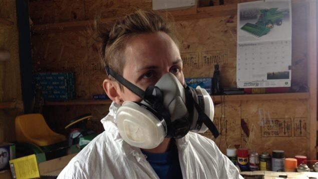 Une agricultrice se protège avant d'épandre des pesticides. Une agricultrice se protège avant d'épandre des pesticides.