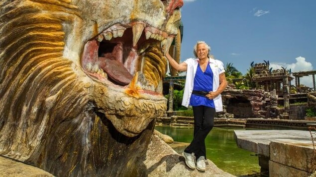 Peter Nygard près d’une têtes de lion surdimensionnées