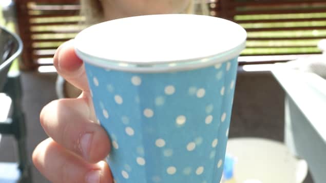 Une jeune fille tient une tasse. Une jeune fille tient une tasse.