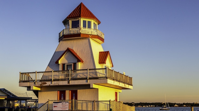 Le phare au coucher du soleil sur le bord de la baie.