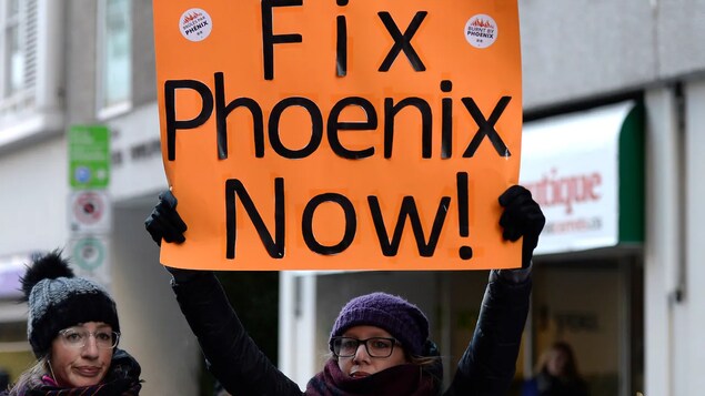 Une manifestante brandit une affiche sur laquelle on peut lire "Fix Phoenix Now!", en référence au système de paye dans la fonction publique fédérale.