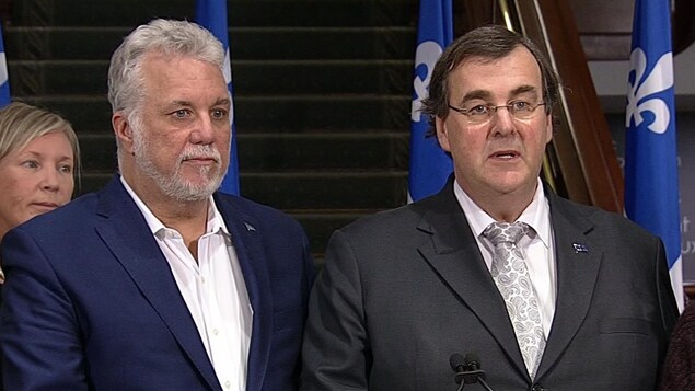 Plan moyen des deux hommes debout derrière un lutrin. Plan moyen des deux hommes debout derrière un lutrin.