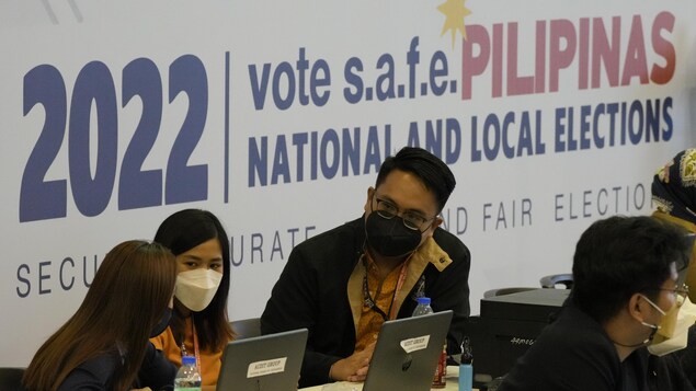 Nakaupo ang staff ng COMELEC.