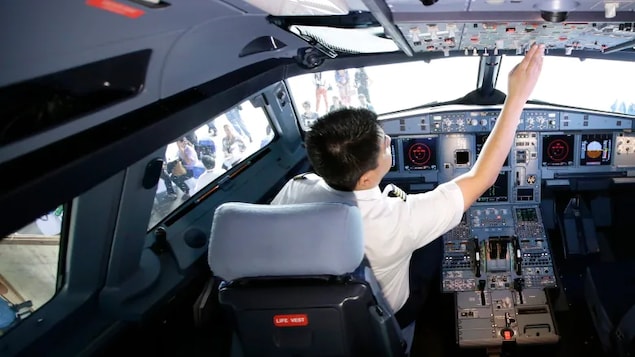a pilot reaches for the cockpit controls. A B.C. woman claims her airline pilot husband flew their daughter to China, where they both remain.