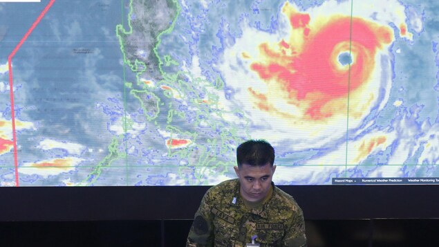 Un membre de l’armée de l’air philippine se tient devant une image satellite du typhon Mangkhut, le 13 septembre 2018.
Un membre de l’armée de l’air philippine se tient devant une image satellite du typhon Mangkhut, le 13 septembre 2018.