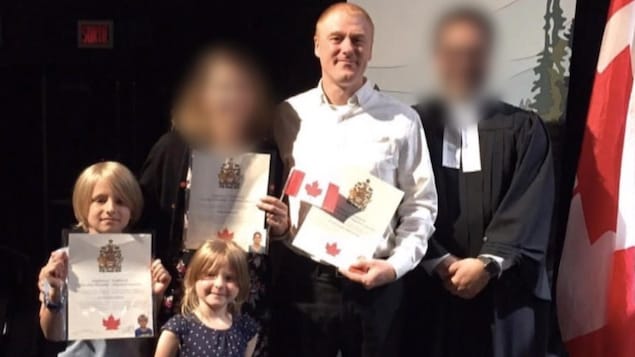 Photo des deux enfants et de l'homme avec deux autres personnes dont le visage a été brouillé.