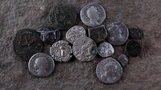 Des pièces de métal antiques déposées sur le sol.