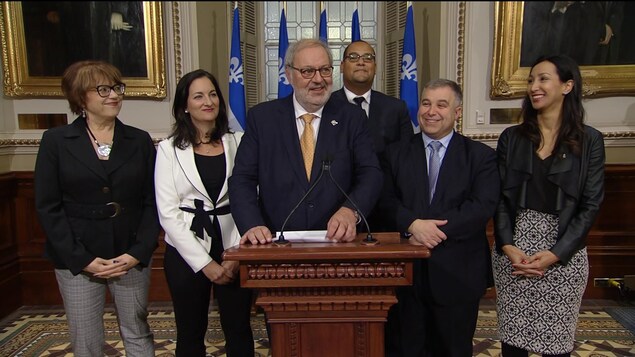 Pierre Arcand devant un lutrin, entouré des députés libéraux Hélène David, Marie Montpetit, Sébastien Proulx, Marwah Rizqy et Saul Polo. Pierre Arcand devant un lutrin, entouré des députés libéraux Hélène David, Marie Montpetit, Sébastien Proulx, Marwah Rizqy et Saul Polo.