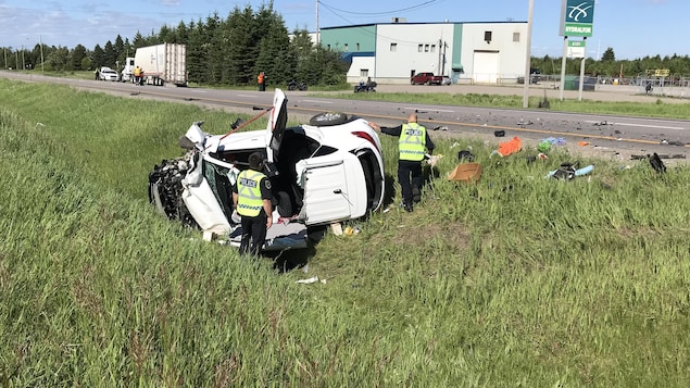 Pierre Girard et un de ses collègues examinent un véhicule accidenté. Pierre Girard et un de ses collègues examinent un véhicule accidenté.