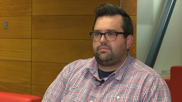 Une homme écoute la question d'un journaliste hors champ. Une homme écoute la question d'un journaliste hors champ.