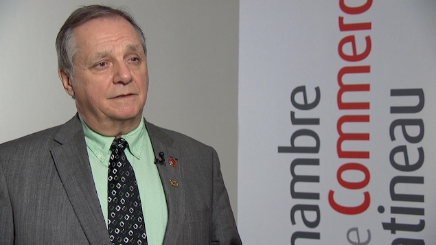 Pierre Samson en entrevue devant une bannière comportant le logo de l'organisme.
