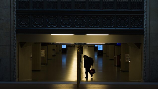 Un piéton marche seul devant la gare Union à Toronto.
