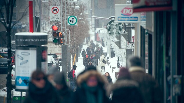 Piétons sur la rue Sainte-Catherine de Montréal, près de la Place des Arts, en hiver