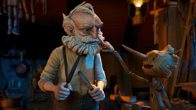 Une image d'un film d'animation montre Pinocchio toucher le nez de Gepetto du bout de son doigt, dans l'atelier de menuiserie.
