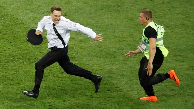 Piotr Verzilov est poursuivi par un gardien après avoir foulé la pelouse lors de la finale de la Coupe du monde de football à Moscou, le 15 juillet 2018. Piotr Verzilov est poursuivi par un gardien après avoir foulé la pelouse lors de la finale de la Coupe du monde de football à Moscou, le 15 juillet 2018.