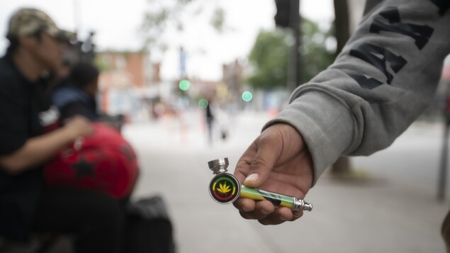 Une main tenant une pipe pour fumer du cannabis.